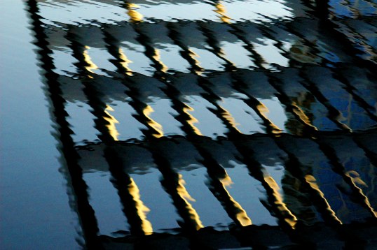 The aluminum grid of the Winspear Opera House sunshade - very high overhead, reflected in the pool.