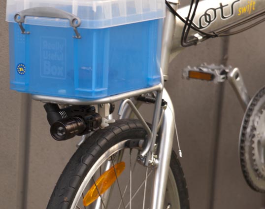 The rack and flashlight on the bike, along with a small pump (maybe I'll post how I hold that to the rack) and a little plastic box from Office Depot, held on with nylon bolts and wingnuts in holes drilled through the box and rack. It looks sort of stupid, but is very useful to hold my wallet, phone, keys, lock... that sort of stuff. 