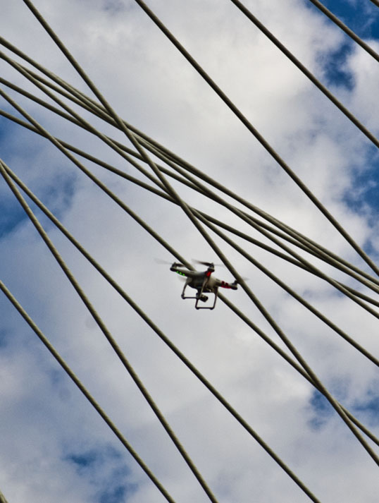 The drone with the cable stays of the Margaret Hunt Hill Bridge in the background.